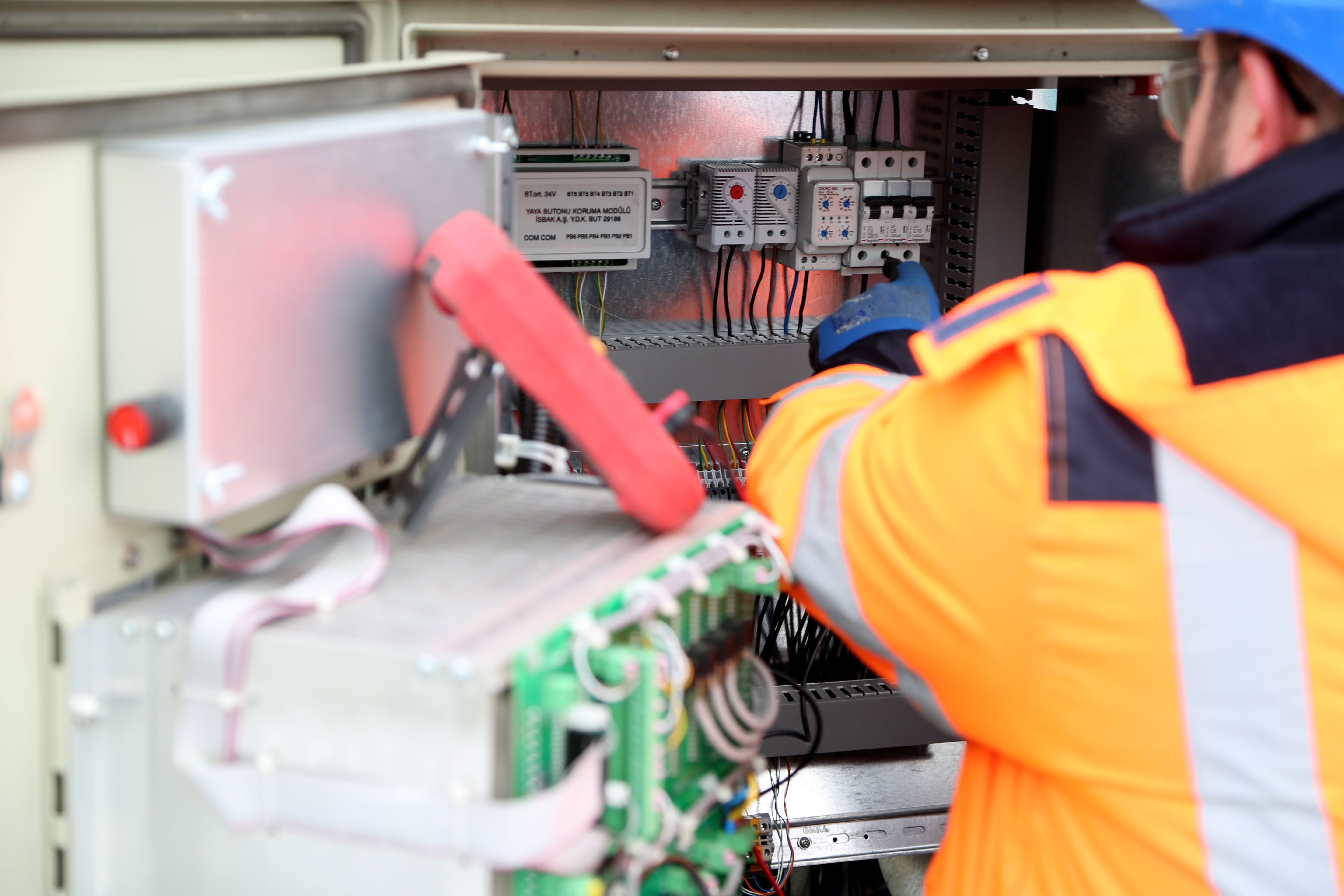 Electrician working inside an electrical control cabinet
