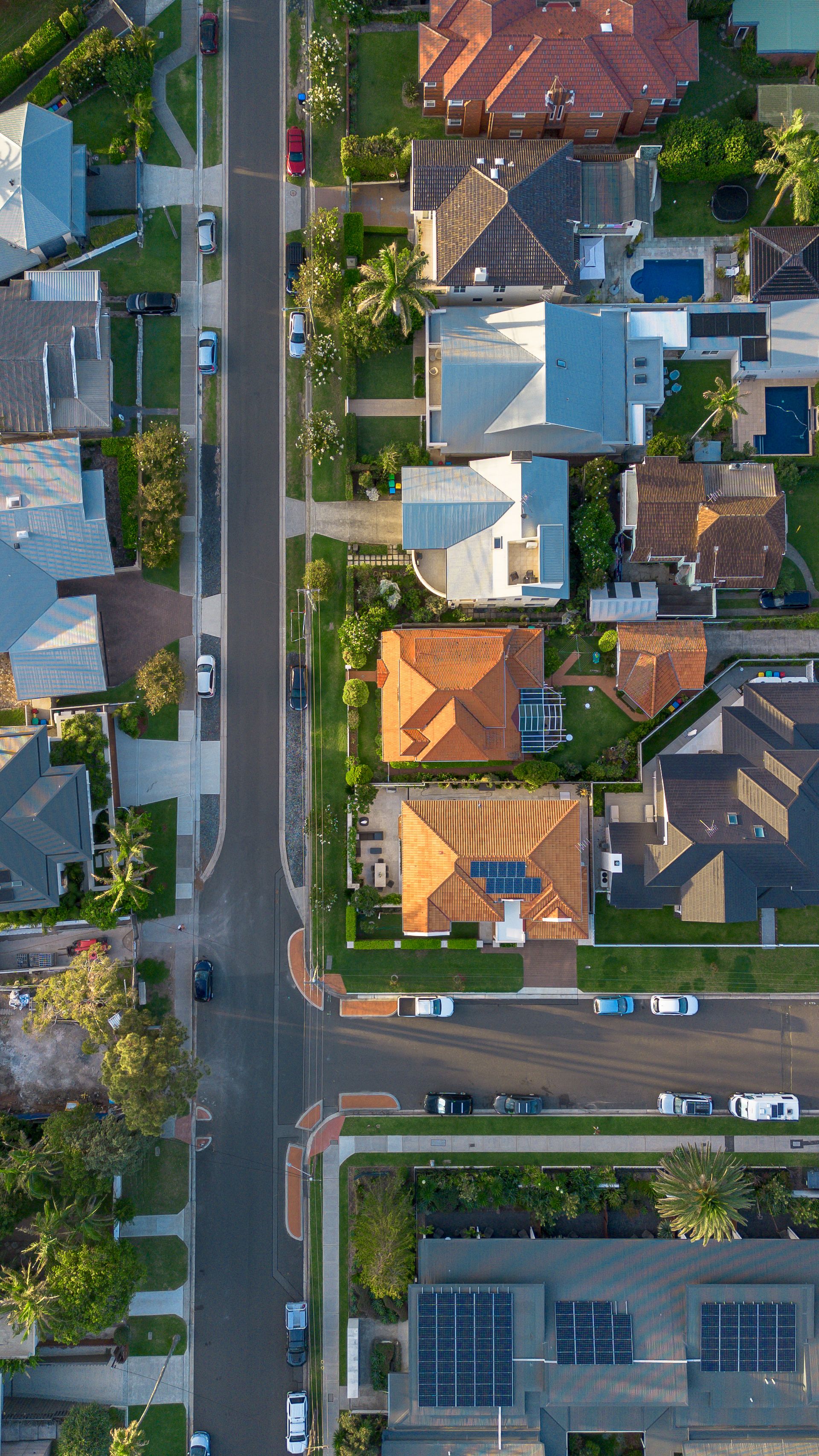 Aerial view of an Australian suburb with terracotta roofs and backyard pools