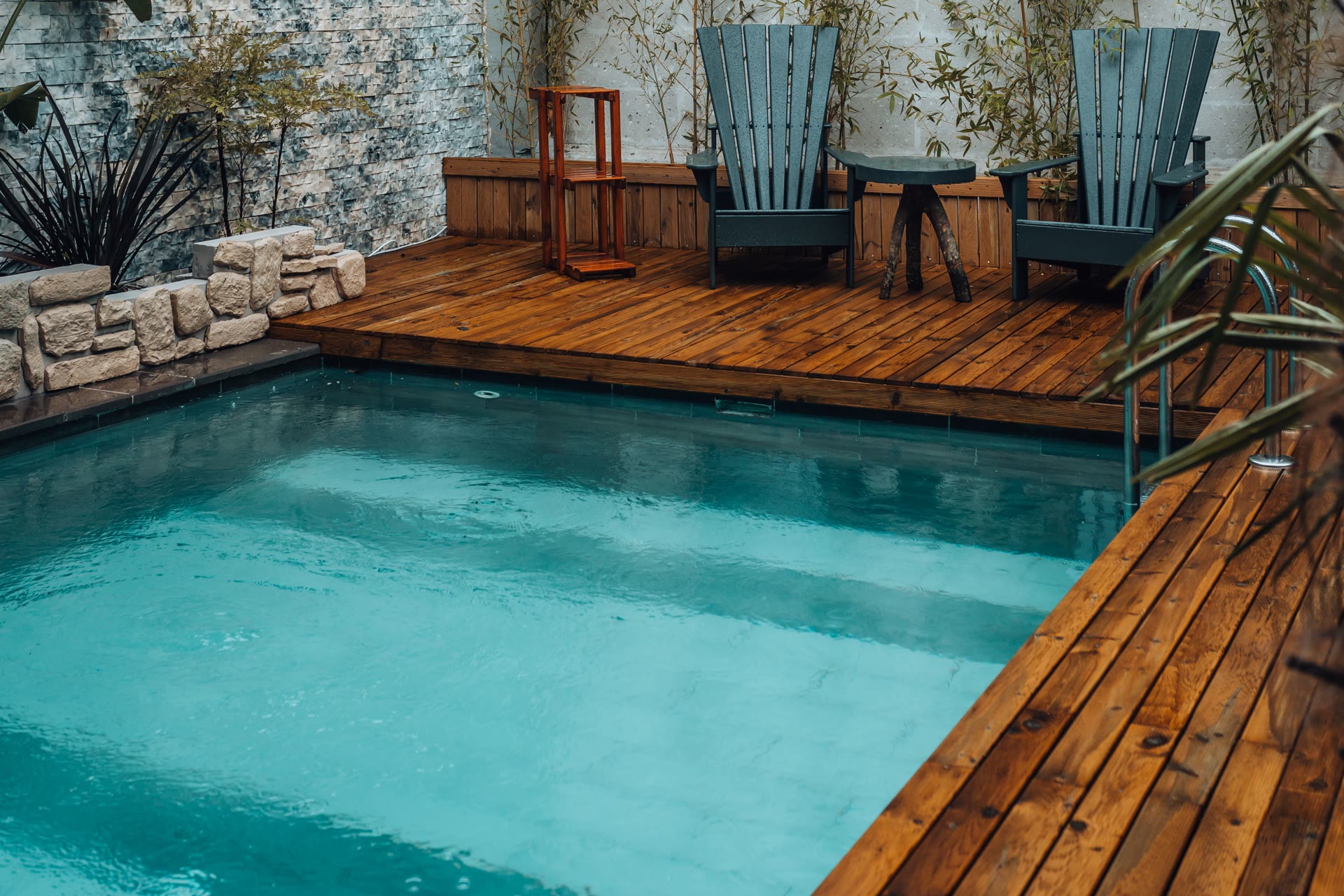 Clear backyard pool beside a timber deck with two chairs